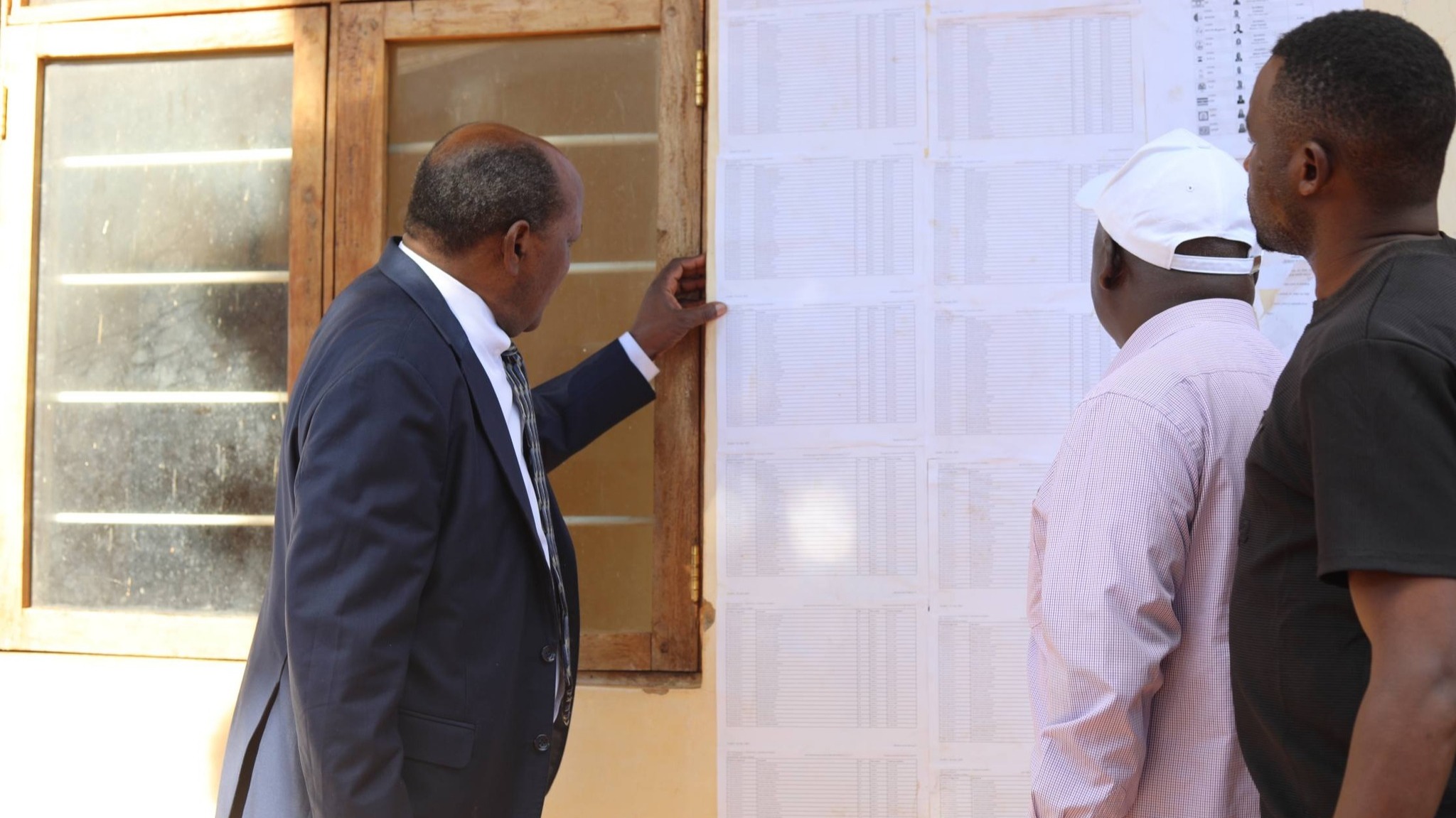 Mwenyekiti wa INEC,  Mhe. Jaji (Rufaa) Jacobs C. M. Mwambegele akikagua orodha ya wapiga kura kwanye kituo cha kupigia kura cha Ghala la Kijiji cha Kihorogota kilichopo Jimbo la Ismani
